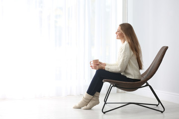 Poster - Young woman resting in armchair at home. Space for text