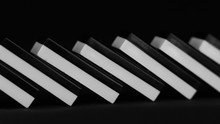 Domino Effect. Row Of White And Black Fallen Dominoes. Chain Reaction And Failure Concept. The Domino Principle. Falling Dominoes. Pan From Right To Left Shot. Lying Down.