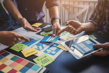 ux/ui team of designers helping to create content and forms of mobile applications to make it easier
