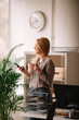 © JustLife - Young businesswoman in office. Beautiful woman drinking coffee and typing message.