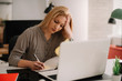 © JustLife - Young tired businesswoman in the office. Beautiful woman sitting in office having headache.