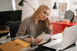 © JustLife - Young tired businesswoman in the office. Beautiful woman sitting in office having headache.
