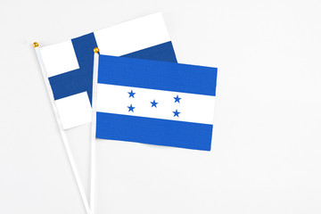 Honduras and Finland stick flags on white background. High quality fabric, miniature national flag. Peaceful global concept.White floor for copy space.