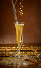 one glass of sparkling champagne with gold decoration