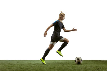 Wall Mural - Young female soccer or football player with long hair in sportwear and boots kicking ball for the goal in jump on white background. Concept of healthy lifestyle, professional sport, motion, movement.