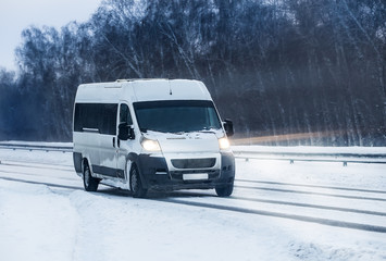Wall Mural - minibus moves in the winter on a highway
