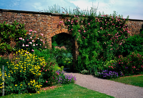 Cuadros en Lienzo A Walled garden with climbing roses and a flower border at a Country House