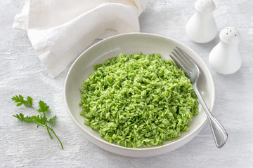 Wall Mural - Vegan rice with green oil in a white bowl on a gray background. delicious healthy homemade food	