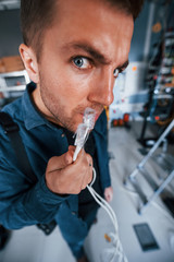 Wall Mural - Close up view of funny man with internet wires in server room