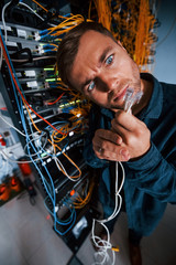 Wall Mural - Close up view of funny man with internet wires in server room