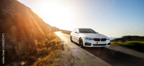 Fotografía white BMW 5 from 2019 series car in spain mountain landscape road at sunset