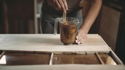 Wall Mural - Carpenter mixing golden powder into epoxy resin