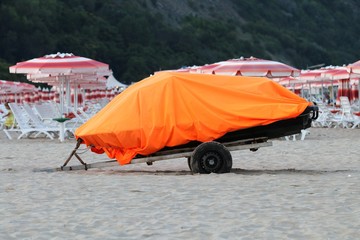  Trailer on the beach. Boat on the trailer. Boat covered with orange tent