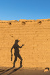 © Chris - Shadow of woman in cowboy hat against mud brick wall