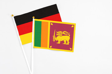 Wall Mural - Sri Lanka and Germany stick flags on white background. High quality fabric, miniature national flag. Peaceful global concept.White floor for copy space.