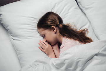 Wall Mural - top view of cute child sleeping on white bedding