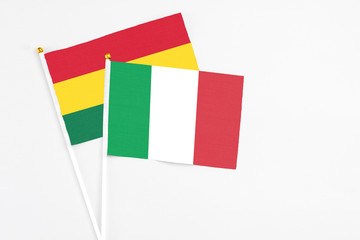 Italy and Ghana stick flags on white background. High quality fabric, miniature national flag. Peaceful global concept.White floor for copy space.