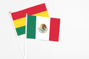 Mexico and Ghana stick flags on white background. High quality fabric, miniature national flag. Peaceful global concept.White floor for copy space.