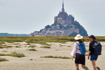 Zwei Frauen nähern sich im Watt dem Mont St. Michel