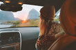 © EVERST - Woman on road trip traveling by rental car relaxing with coffee cup adventure lifestyle vacations vibes outdoor sunset Norway mountains view in window