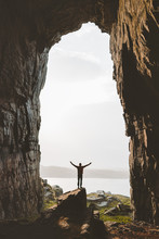 Man Standing Alone In Cave Travel Adventure Vacations Happy Raised Hands Tourist Success Wellness Concept Kirkehelleren Grotto In Norway