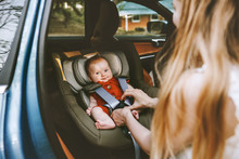 Mother Putting Baby In Safety Car Seat Family Lifestyle Child Care Transportation Road Trip Vacations