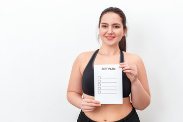 Wall Mural - Body Care. Chubby girl standing isolated on white holding diet plan smiling cheerful