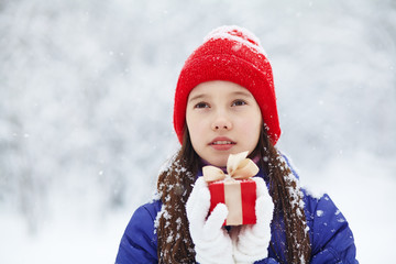 teenage girl with a gift in her hands. adolescent winter outdoors