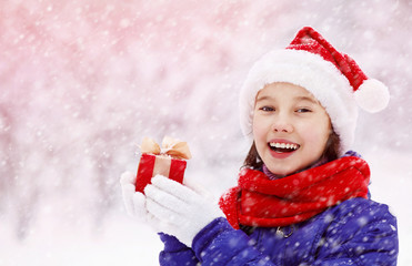 Wall Mural - teenage girl with a gift in her hands. adolescent winter outdoors