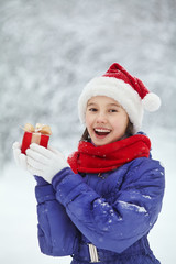 Wall Mural - teenage girl with a gift in her hands. adolescent winter outdoors