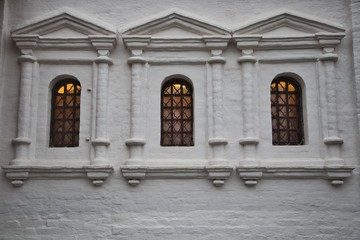 Three Windows in a white stone wall