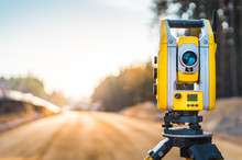 Surveyors Equipment (theodolite Or Total Positioning Station) On The Construction Site Of The Road Or Building With Construction Machinery Background