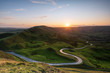 © robertharding - Long and winding rural road leading through green hills in the Peak District, with Rushup Edge, Peak District National Park, Derbyshire
