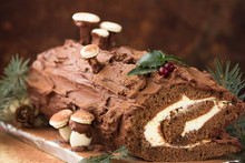Chocolate Yule Log Christmas Cake On Wooden Background.