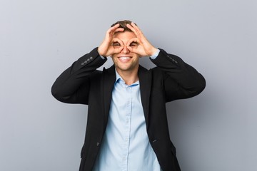 Wall Mural - Young handsome caucasian man showing okay sign over eyes