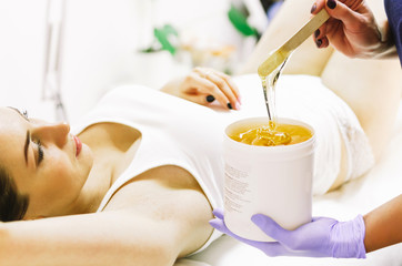 woman doing hot sugar wax hair removal