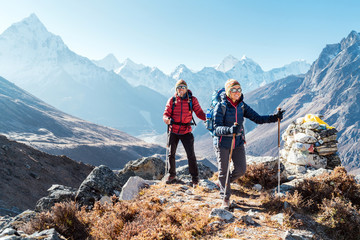 couple following everest base camp trekking route near dughla 4620m. backpackers carrying backpacks 