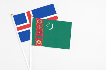 Turkmenistan and Iceland stick flags on white background. High quality fabric, miniature national flag. Peaceful global concept.White floor for copy space.