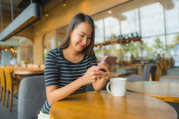 Canvas Print - Portrait beautiful young asian women in coffee shop cafe and restaurant with mobile phone