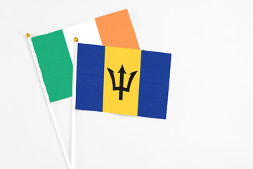 Barbados and Ireland stick flags on white background. High quality fabric, miniature national flag. Peaceful global concept.White floor for copy space
