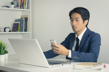 Asian Financial Advisor or Asian Consulting Businessman Contact with Customer by Smartphone in Vintage Tone