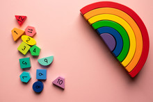 Bright Wooden Rainbow Toy And Rainbow Colored Blocks On A Pink Background - Creative Montessori Toy Concept Flat Lay Frame