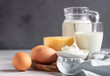 Different types of fresh dairy products and eggs on wooden plate. Natural farm products.