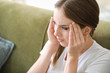 © Pixel-Shot - Young woman suffering from headache at home