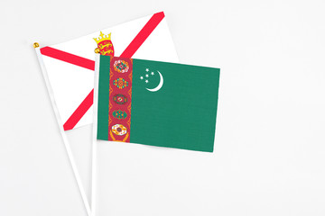 Turkmenistan and Jersey stick flags on white background. High quality fabric, miniature national flag. Peaceful global concept.White floor for copy space.