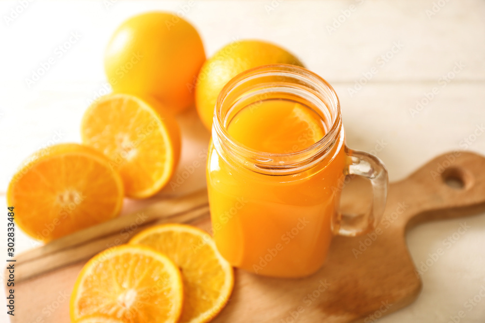 Mason jar of fresh orange juice on table