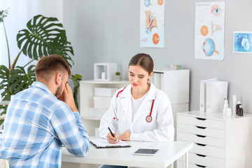 Wall Mural - Female doctor working with sad male patient in clinic