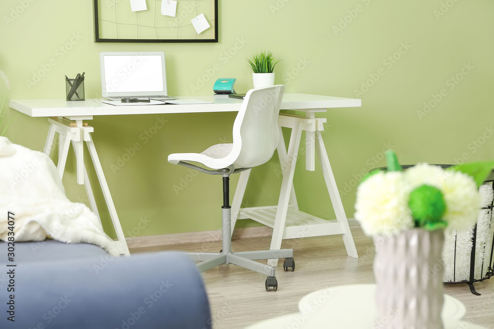 Modern stylish workplace with laptop in interior of room