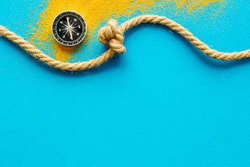 Wall Mural - Goal achievement concept. Compass near rope with knot on blue background top view copy space