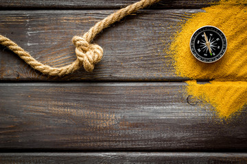 Wall Mural - Goal achievement concept. Compass near rope with knot on dar wooden background top view copy space